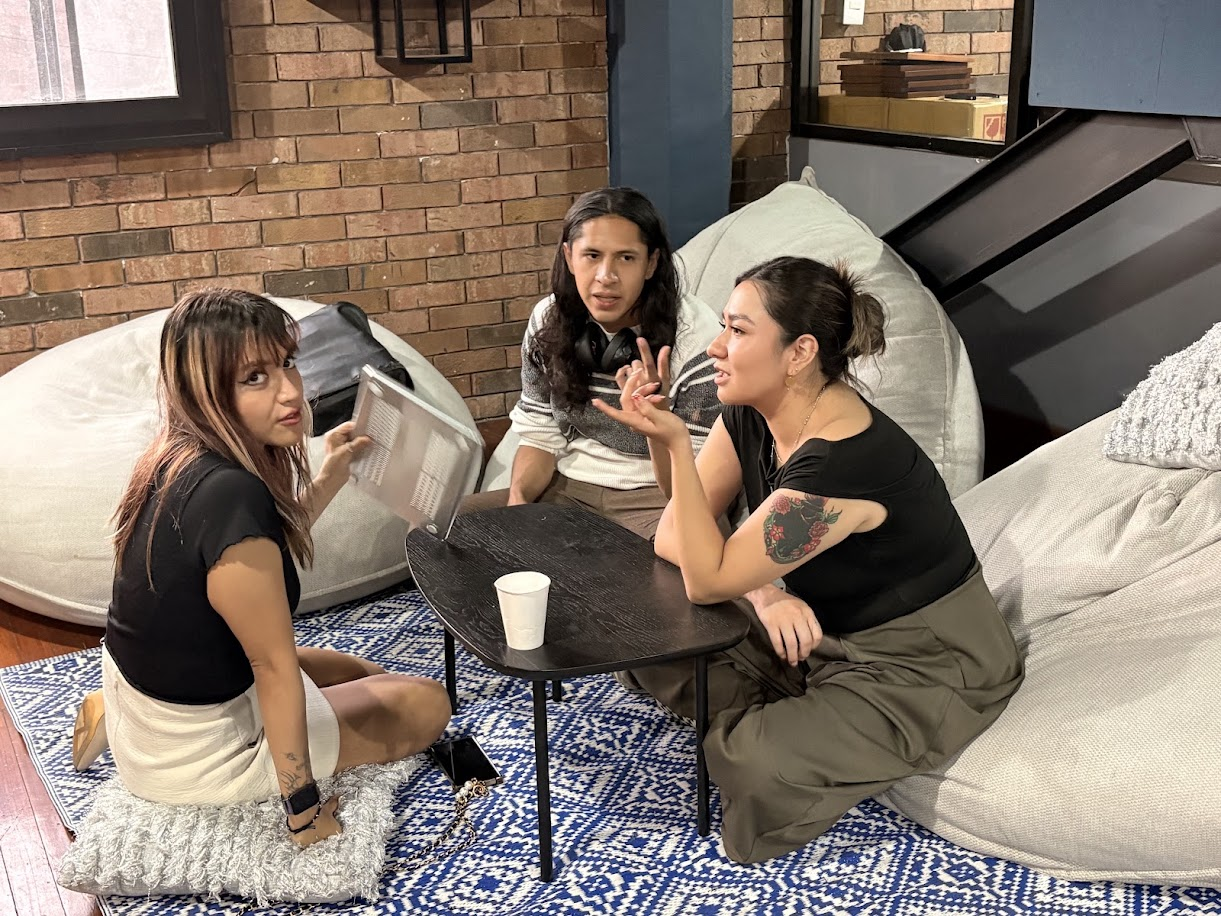 Mafer Galindo conversando con dos participantes en un hackathon